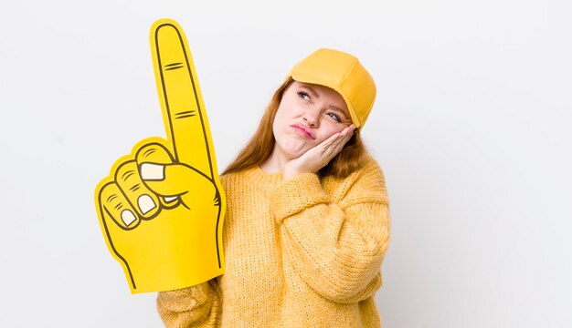 Mujer bonita pelirroja que se siente aburrida, frustrada y con sueño después de un aburrido concepto de ventilador de mano número uno