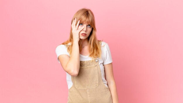 Mujer bonita pelirroja que se siente aburrida, frustrada y con sueño después de un cansado