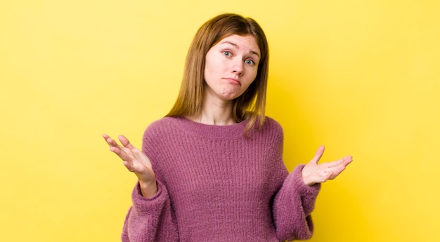 Mujer bonita pelirroja que se siente desconcertada y confundida, insegura sobre la respuesta o decisión correcta tratando de tomar una decisión