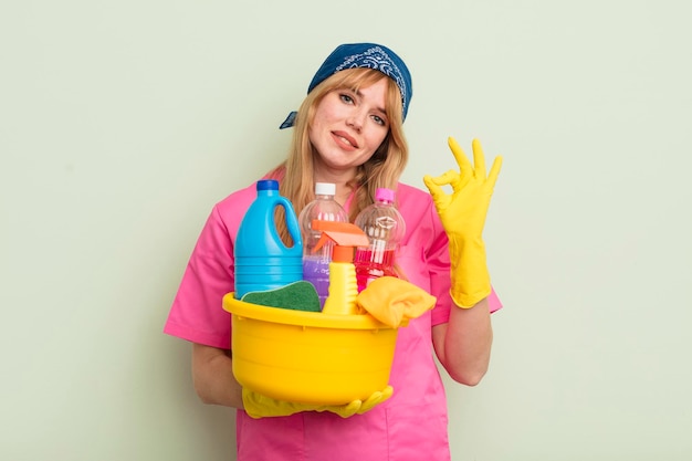 Mujer bonita pelirroja que se siente feliz mostrando aprobación con un concepto de limpiador de limpieza de gestos bien