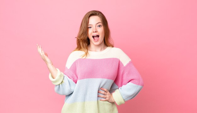 Mujer bonita pelirroja que se siente feliz, sorprendida al darse cuenta de una solución o idea