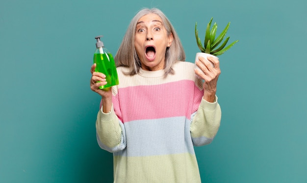 Mujer bonita de pelo gris con un cactus