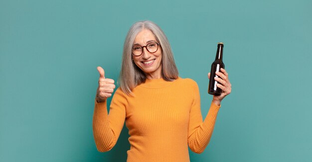 Mujer bonita de pelo gris tomando una cerveza