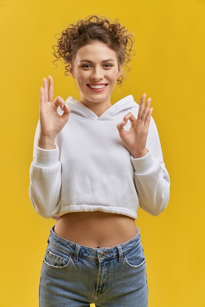 Mujer bonita con el pelo rizado de pie sonriendo