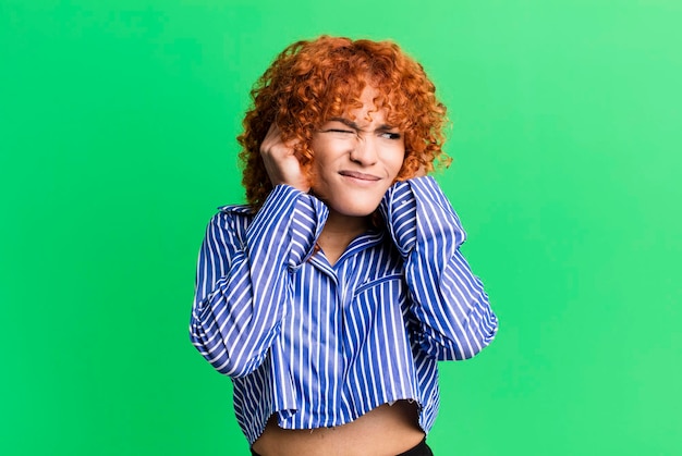 Mujer bonita de pelo rojo contra el fondo aislado