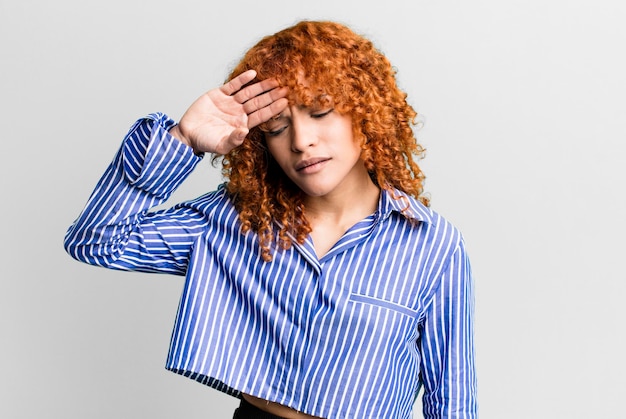 Mujer bonita de pelo rojo contra el fondo aislado