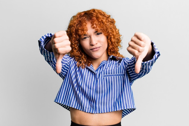 Mujer bonita de pelo rojo contra el fondo aislado