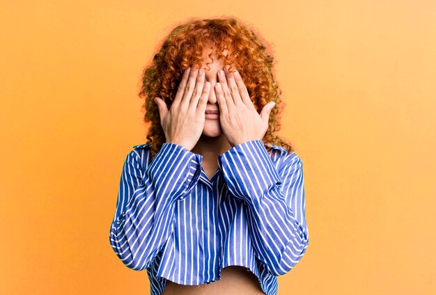 Mujer bonita de pelo rojo contra el fondo aislado