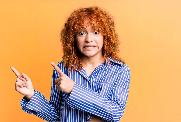 Mujer bonita de pelo rojo contra el fondo aislado