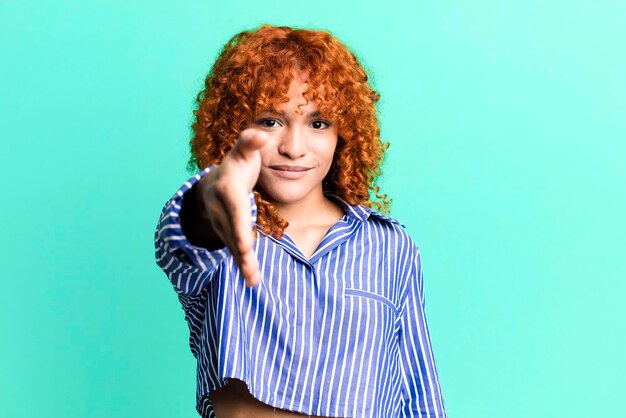 Mujer bonita de pelo rojo contra el fondo aislado