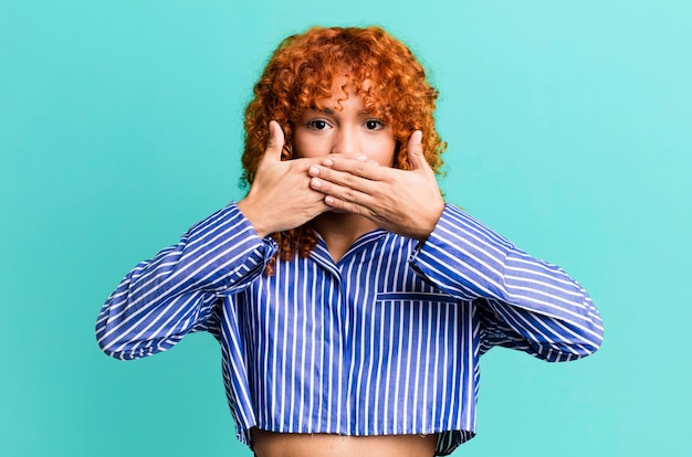 Mujer bonita de pelo rojo contra el fondo aislado