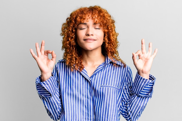 Mujer bonita de pelo rojo contra el fondo aislado