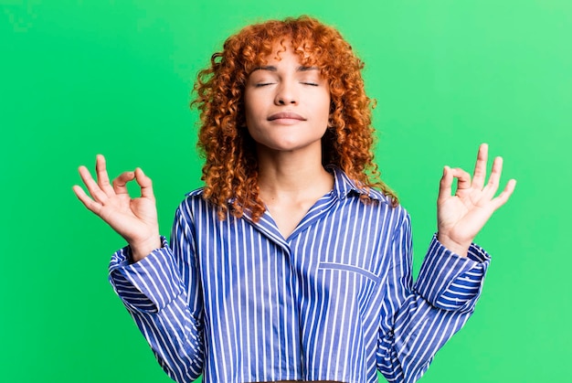 Mujer bonita de pelo rojo contra el fondo aislado