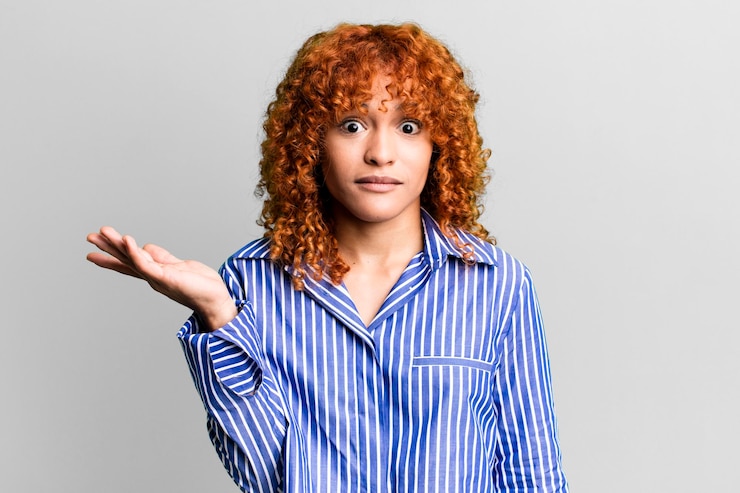 Foto mujer bonita de pelo rojo contra el fondo aislado