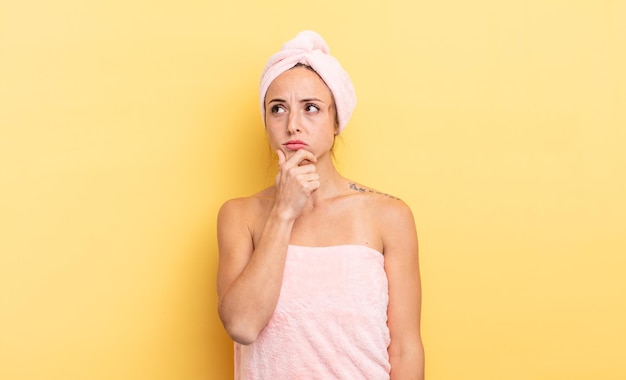 Mujer bonita pensando, sintiéndose dudosa y confundida. concepto de ducha y belleza