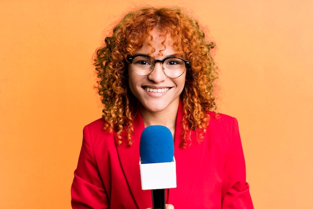 Mujer bonita periodista o presentadora de pelo rojo con un micro