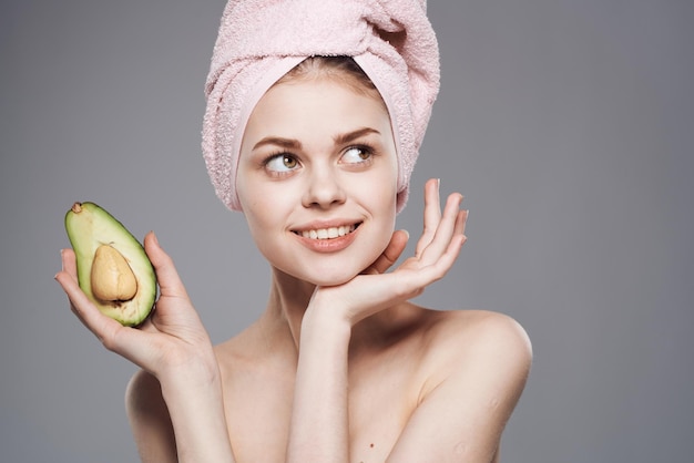 Mujer bonita piel limpia aguacate en mano procedimiento de cosméticos de salud