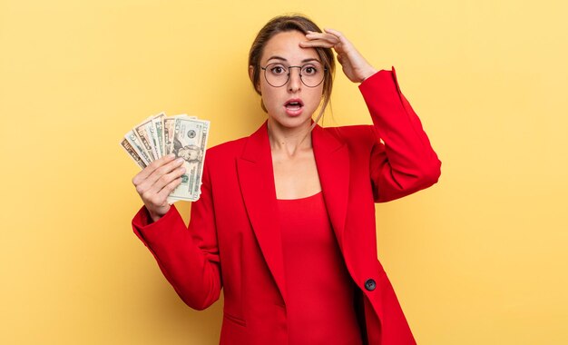 Mujer bonita que parece feliz, asombrada y sorprendida. concepto de negocios y billetes de dólar