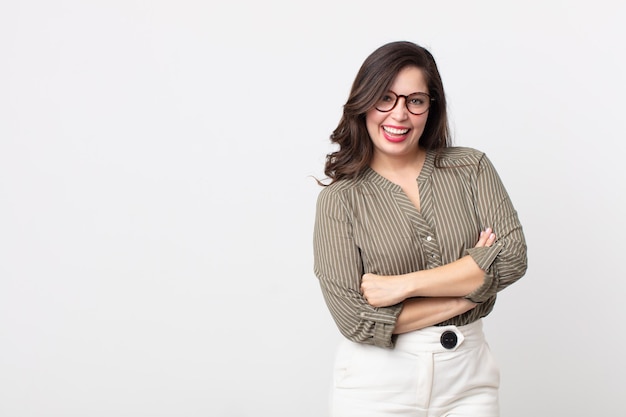 Mujer bonita que parece una feliz triunfadora orgullosa y satisfecha sonriendo con los brazos cruzados