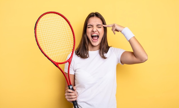 Mujer bonita que parece infeliz y estresada gesto de suicidio haciendo concepto de jugador de tenis de signo de pistola