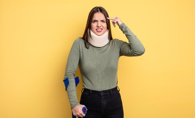 Mujer bonita que se siente confundida y desconcertada, mostrando que estás loca. concepto de accidente lesionado