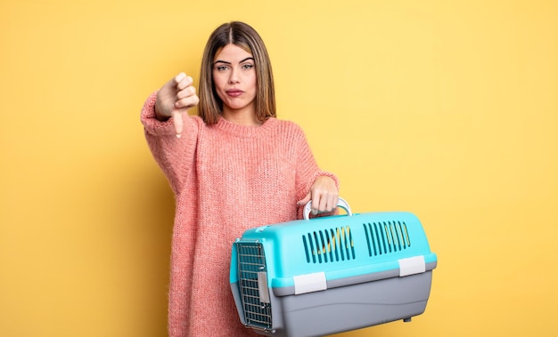 Mujer bonita que se siente cruzada, mostrando los pulgares hacia abajo. concepto de portador de mascotas