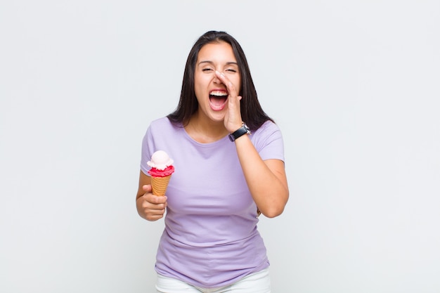 Mujer bonita que se siente feliz, emocionada y positiva, dando un gran saludo