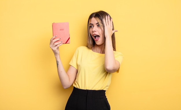 Mujer bonita que se siente feliz, emocionada y sorprendida del concepto de planificador