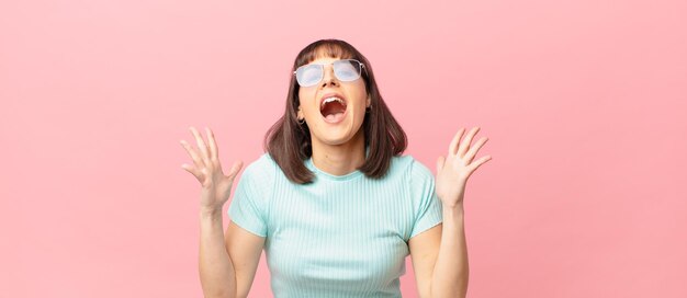 Mujer bonita que se siente feliz, emocionada, sorprendida o conmocionada, sonriendo y asombrada por algo increíble