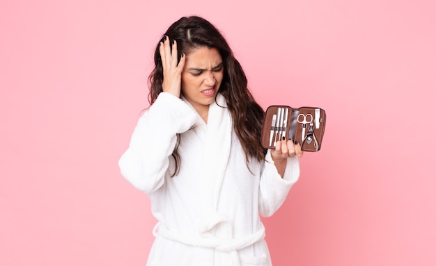 Mujer bonita que se siente feliz, emocionada y sorprendida y sosteniendo una bolsa de maquillaje con herramientas de uñas