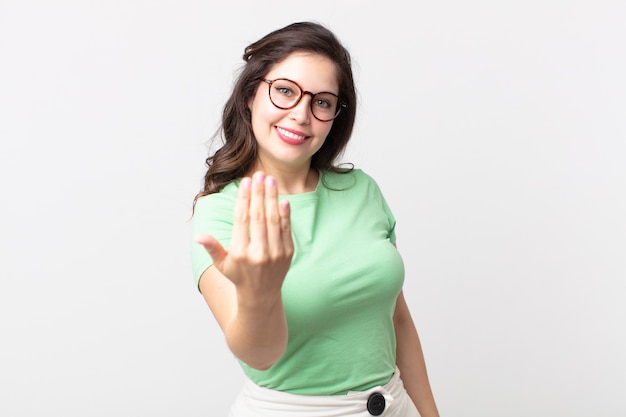 Una mujer bonita que se siente feliz, exitosa y confiada, enfrenta un desafío y dice ¡adelante! o dándote la bienvenida