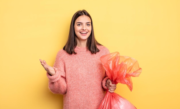 Mujer bonita que se siente feliz sorprendida al darse cuenta de una solución o concepto de bolsa de basura de idea