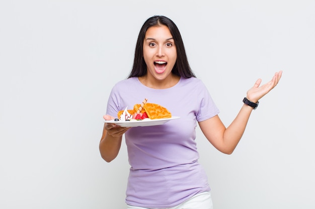 Mujer bonita que se siente feliz, sorprendida y alegre, sonriendo con actitud positiva, dándose cuenta de una solución o idea