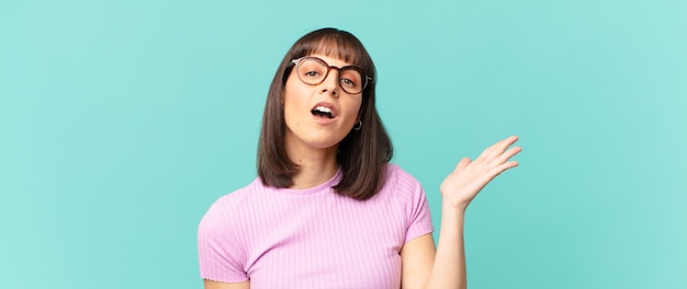 Mujer bonita que se siente feliz, sorprendida y alegre, sonriendo con actitud positiva, dándose cuenta de una solución o idea