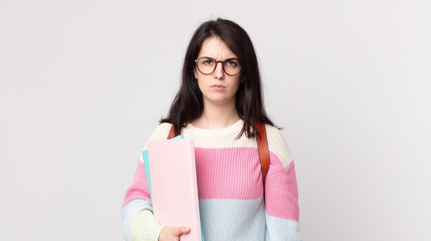 Mujer bonita que se siente triste, molesta o enojada y mira hacia un lado. concepto de estudiante universitario