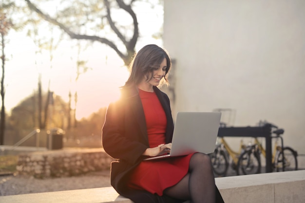 Mujer bonita que trabaja en una computadora portátil