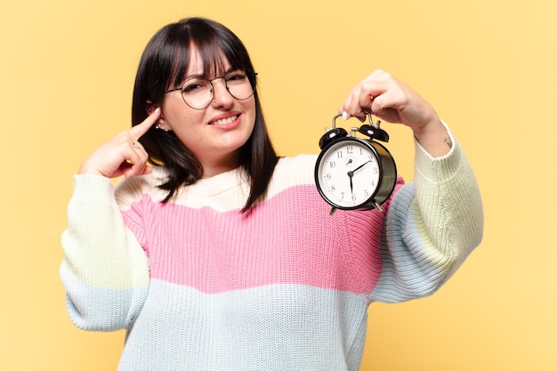 mujer bonita con un reloj despertador