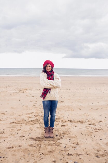 Mujer bonita en ropa de abrigo con estilo en la playa