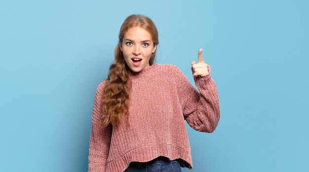 Mujer bonita rubia apuntando con una expresión agresiva enojada que parece un jefe loco y furioso