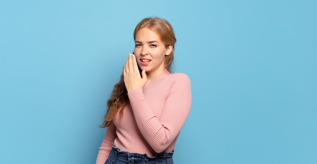 Mujer bonita rubia bostezando perezosamente temprano en la mañana, despertando y mirando con sueño, cansado y aburrido