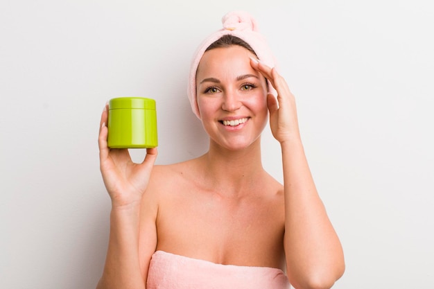 Mujer bonita rubia con una botella de porducto para el cabello