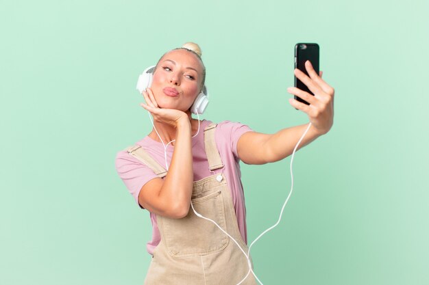 Mujer bonita rubia escuchando música con auriculares