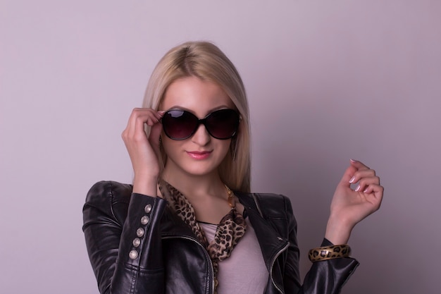 Mujer bonita rubia en gafas y chaqueta de cuero