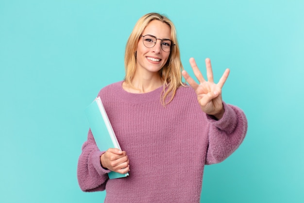 Mujer bonita rubia con libros estudiando