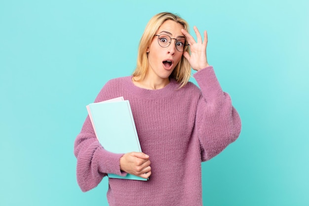 Mujer bonita rubia con libros estudiando