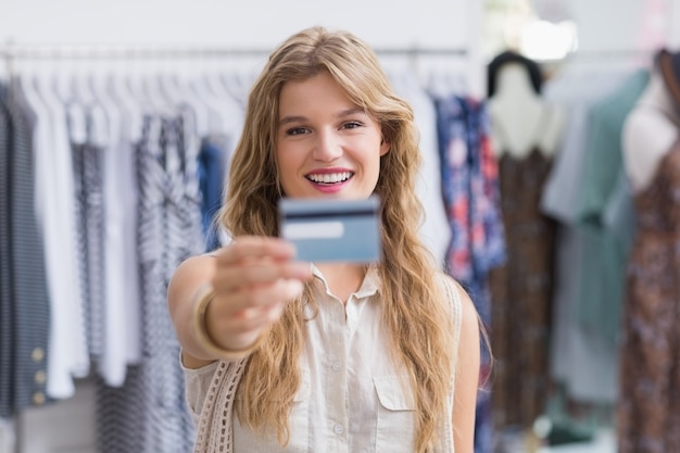 Una mujer bonita rubia mostrando sus tarjetas de crédito