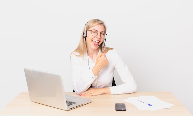 Mujer bonita rubia mujer rubia joven que se siente feliz y enfrenta un desafío o celebra y trabaja con una computadora portátil