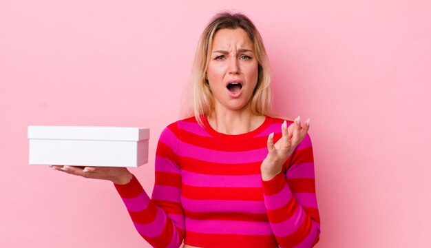 Mujer bonita rubia que parece desesperada frustrada y estresada concepto de caja blanca