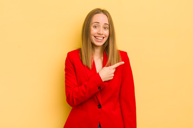 Mujer bonita rubia que parece emocionada y sorprendida señalando el concepto de mujer de negocios lateral