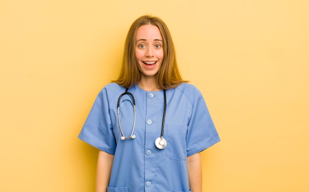 Mujer bonita rubia que parece feliz y gratamente sorprendida concepto de enfermera